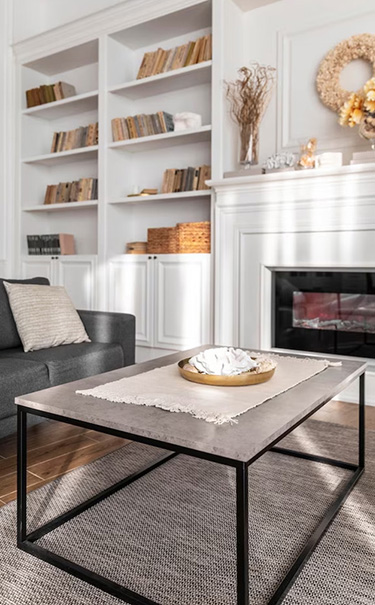 A living room with a fireplace and bookshelf